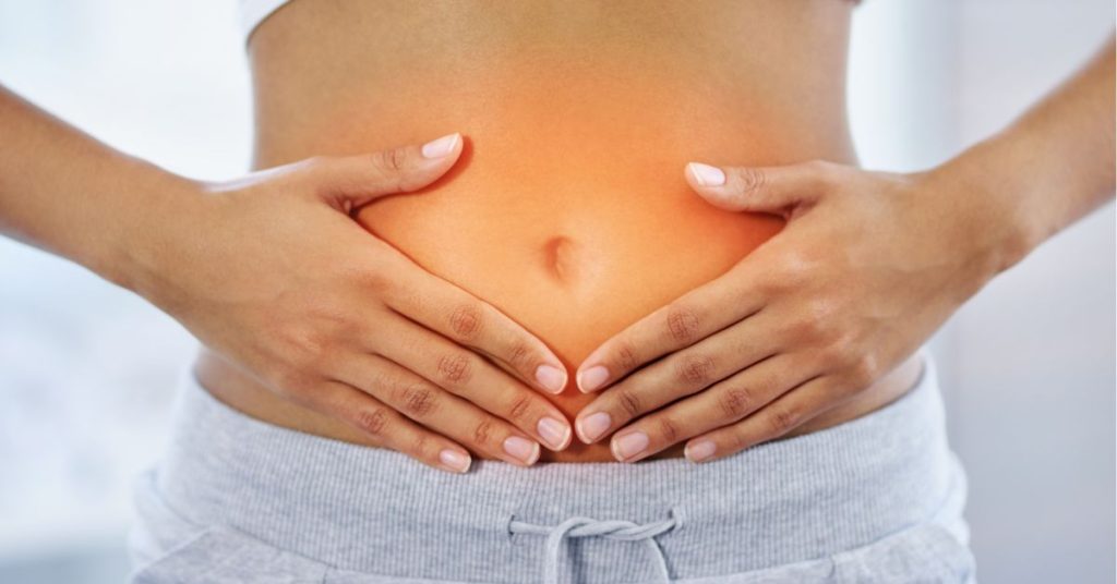Woman with hands on glowing stomach. Read about how gut and brain health are related