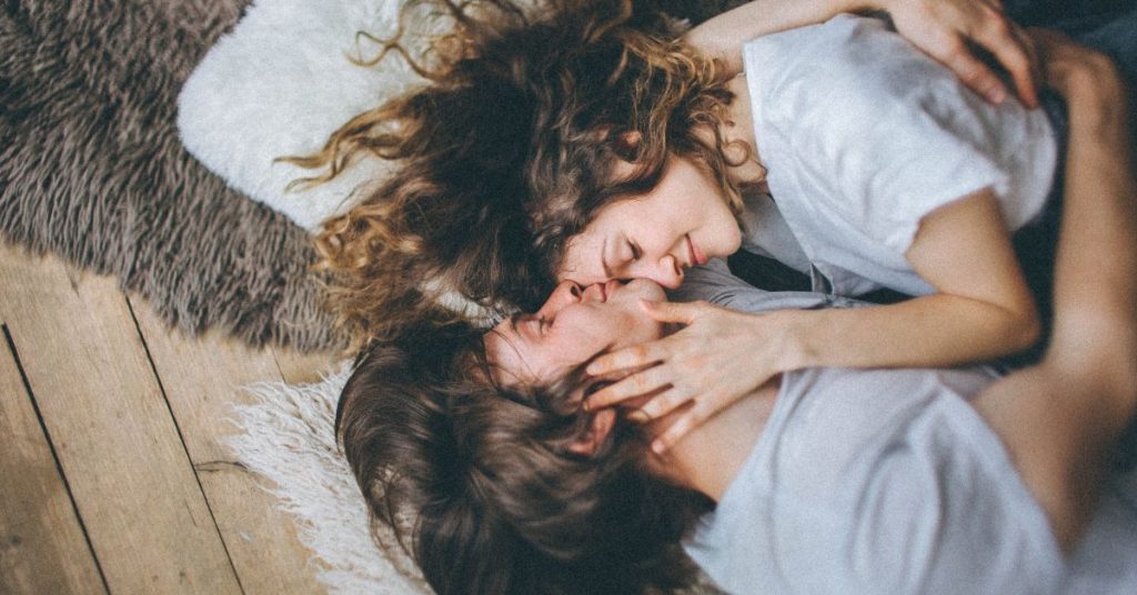 couple laying together with man kissing woman on forehead