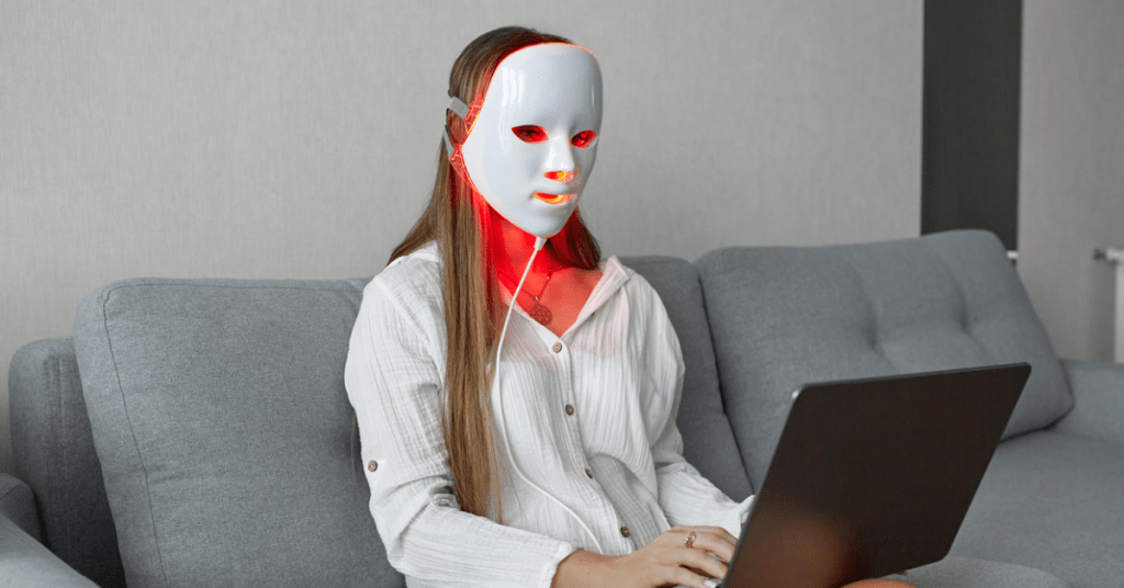 Woman wearing a red light therapy mask