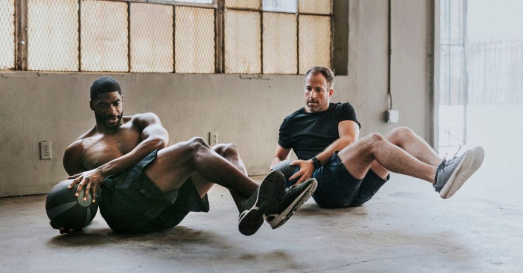 men exercising with weight ball to illustrate that exercise is a key factor in longevity